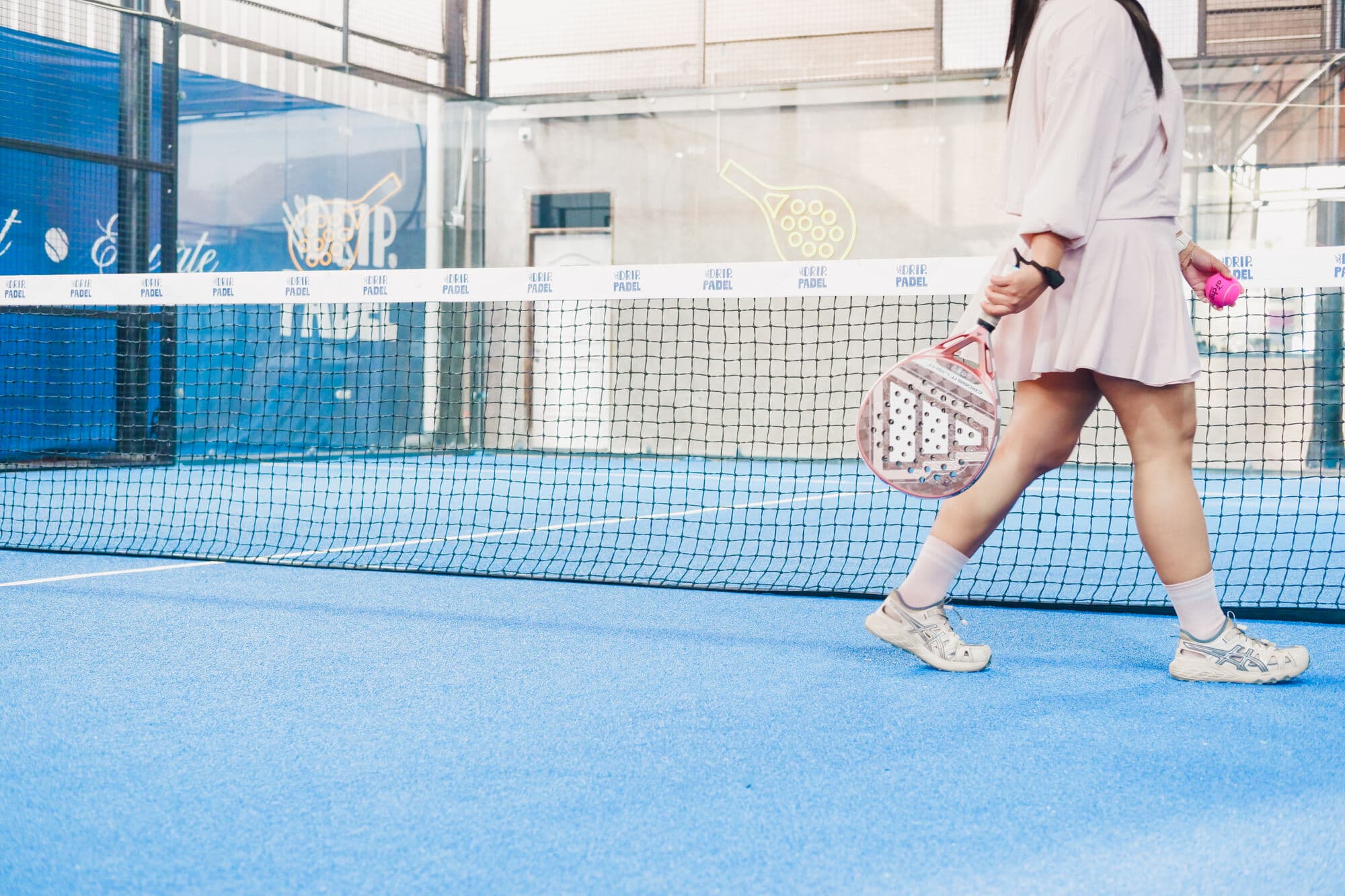 Pemandangan lebar lapangan padel dengan net di tengah
